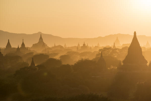 Bagan, Mandalay region, Myanmar (Burma). Stupas silhouettes in the fog at sunset.