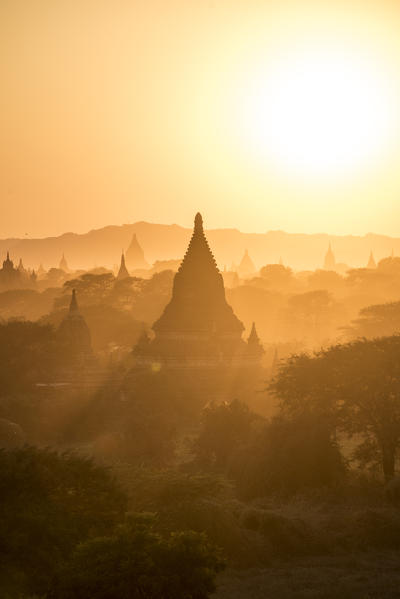 Bagan, Mandalay region, Myanmar (Burma). Stupas silhouettes in the fog at sunset.