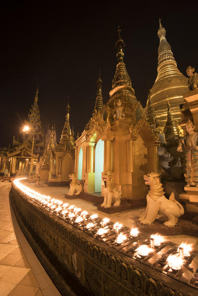 Yangon, Myanmar (Burma). Rows of candles in the Shwedagon pagoda at night.