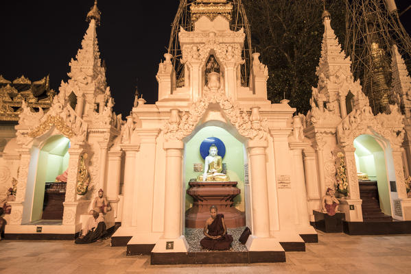 Yangon, Myanmar (Burma). Monk praying in a small stupa of the Shwedagon pagoda at night.