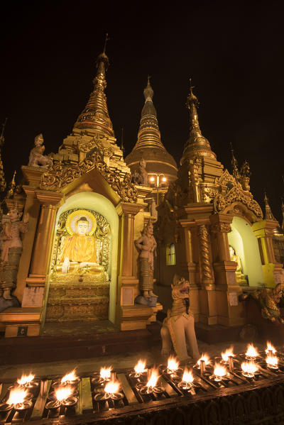 Yangon, Myanmar (Burma). Rows of candles in the Shwedagon pagoda at night.