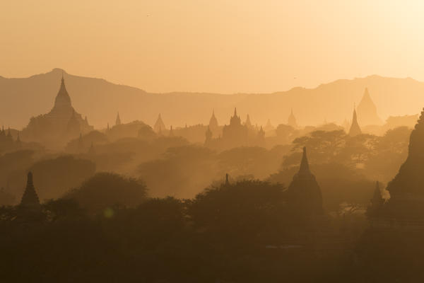 Bagan, Mandalay region, Myanmar (Burma). Stupas silhouettes in the fog at sunset.
