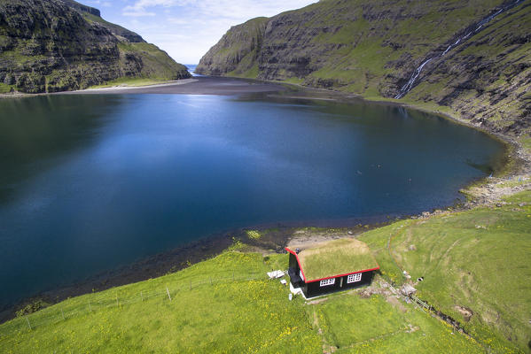 Saksun, Stremnoy island, Faroe Islands, Denmark. Aerial view of the iconic house with grass roof in front of the fiord.
