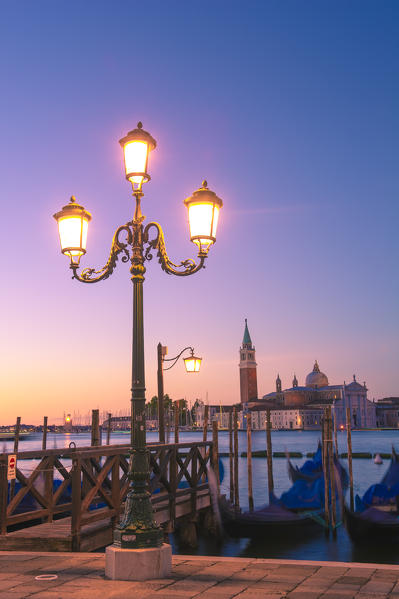 Riva degli Schiavoni, Venice, Veneto, Italy. Moored gondolas in front of St George's church.