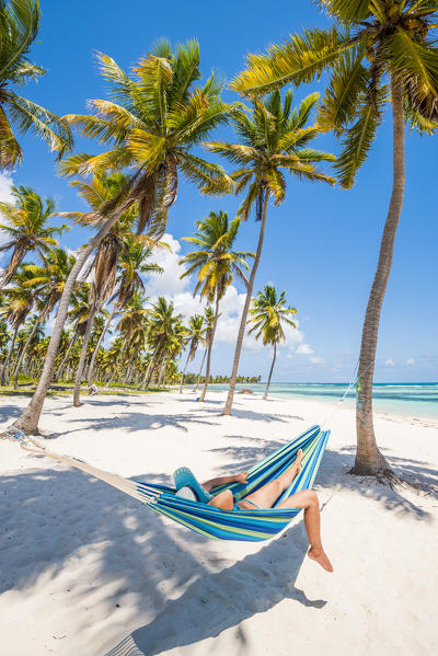 Canto de la Playa, Saona Island, East National Park (Parque Nacional del Este), Dominican Republic, Caribbean Sea. Woman relaxing on a hammock on the beach (MR).
