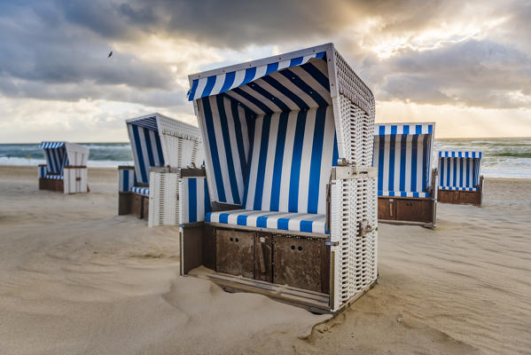 Kampen, Sylt island, North Frisia, Schleswig-Holstein, Germany. Strandkorbs on the beach at sunset.
