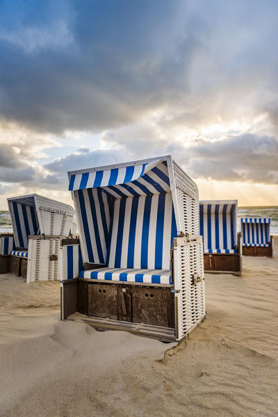 Kampen, Sylt island, North Frisia, Schleswig-Holstein, Germany. Strandkorbs on the beach at sunset.