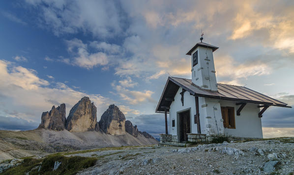 Tre Cime di Lavaredo, Three peaks of lavaredo, Drei Zinnen, Dolomites, South Tyrol, Veneto, Italy. Church and Tre Cime di Lavaredo at sunset