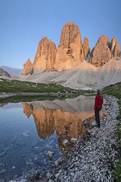 Tre Cime di Lavaredo, three peaks of lavaredo, Drei Zinnen, Dolomites, South Tyrol, Veneto, Italy. Woman staring at Tre Cime di Lavaredo