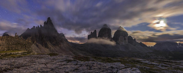 Tre Cime di Lavaredo, Drei Zinnen, Three peaks of Lavaredo, Dolomites, South Tyrol, Veneto, Italy. Tre Cime di Lavaredo, Paterno and Moon in a cloudy night