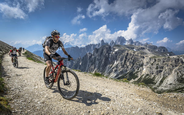 Tre Cime di Lavaredo, Drei Zinnen, Three Peaks of Lavaredo,  Dolomites, Veneto, South Tirol, Italy. Bikers on the pathway.