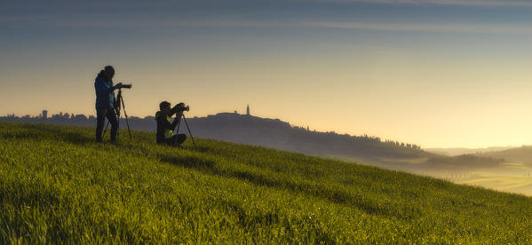 San Quirico d'Orcia countryside, Val d'Orcia, Tuscany, Italy. Photographers on the field.