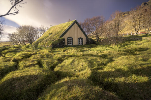A church with the typical turf house, 'torfbaeir' in Icelandic. Iceland, Europe