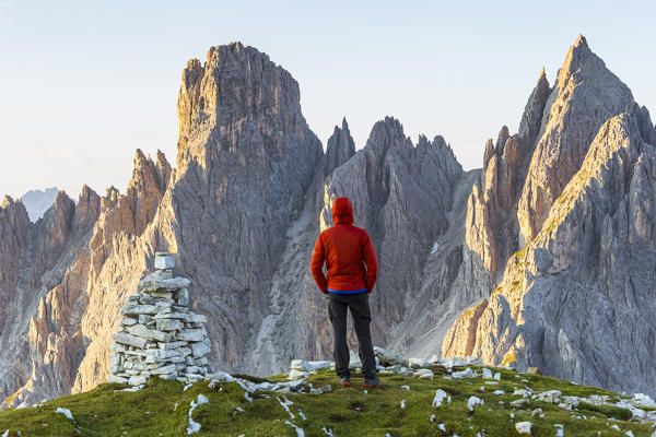 Italy,Veneto,Belluno district,Auronzo di Cadore,a man contemplates the sunrise on the Cadini di Misurina group