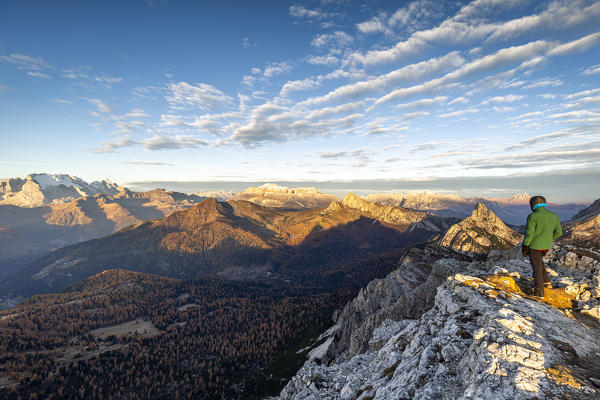 Italy,Veneto,Belluno district,Cortina d'Ampezzo,a man at dawn on top of Mount Croda Negra looks Marmolada group,Mount Col di Lana,Sella group,Mount Settsass and mount Sass de Stria