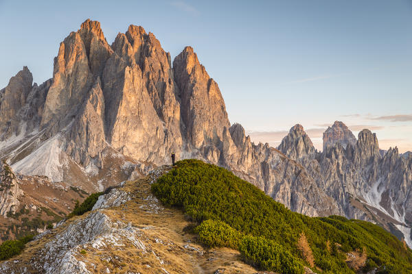 Italy,Veneto,Belluno district,Auronzo di Cadore,a hiker taking photographs of the Cadini di Misurina group at sunrise