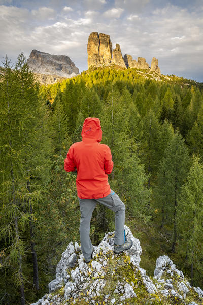 Italy,Veneto,Belluno district,Boite valley,a hiker admires the sunrise over mount Averau and Cinque Torri group