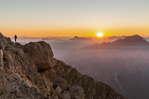 Italy, Veneto, Belluno district, Boite Valley,woman hiker at the top of Tofana di Mezzo admire the sunrise