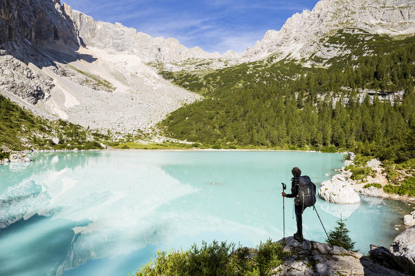 Italy,Veneto,Belluno district,Cortina d'Ampezzo,hiker admires the turquoise water of Lake Sorapis