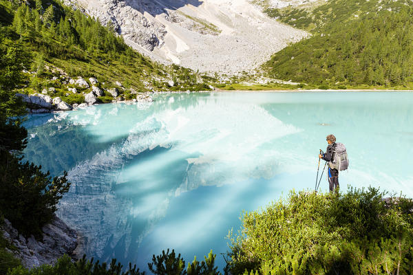 Italy,Veneto,Belluno district,Cortina d'Ampezzo,hiker admires the turquoise water of Lake Sorapis