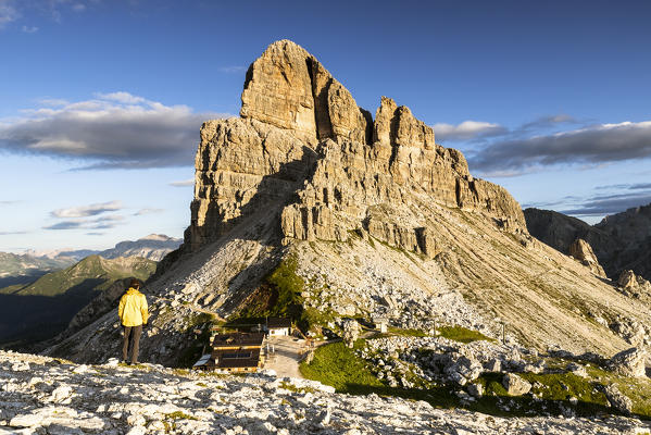 Italy, Veneto, province of Belluno, a hiker admires the sun that lights up the rocks of Mount Averau and the cozy hut (MR)