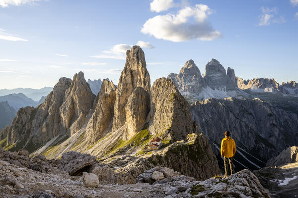 Italy,Veneto,province of Belluno,a hiker enjoys the view over Fonda Savio Hut in the Cadini di Misurina group,with Tre Cime di Lavaredo in the background (MR)