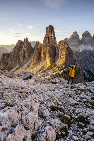Italy,Veneto,province of Belluno,a hiker enjoys the view over Fonda Savio Hut in the Cadini di Misurina group,with Tre Cime di Lavaredo in the background (MR)