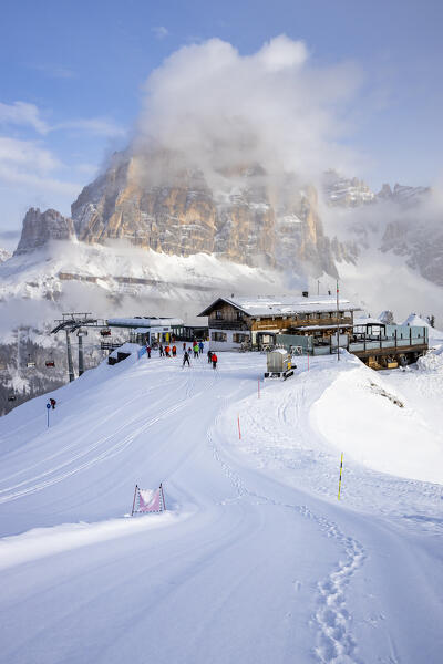 Italy, Veneto, province of Belluno,skiers at the Scoiattoli hut with Tofana di rozes in the background