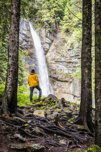 Italy, Veneto, province of Belluno,Borca di Cadore, hiker looks at the Ru de Assola waterfall (MR)