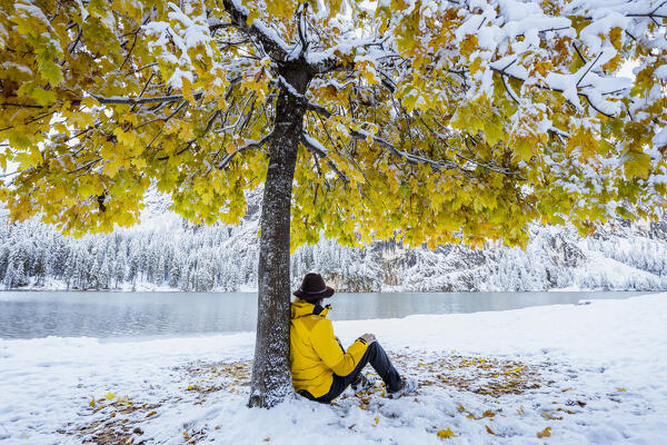 Italy, South Tyrol, Bolzano province, hiker enjoys the peaceful at the Braies lake after snowfall (MR)