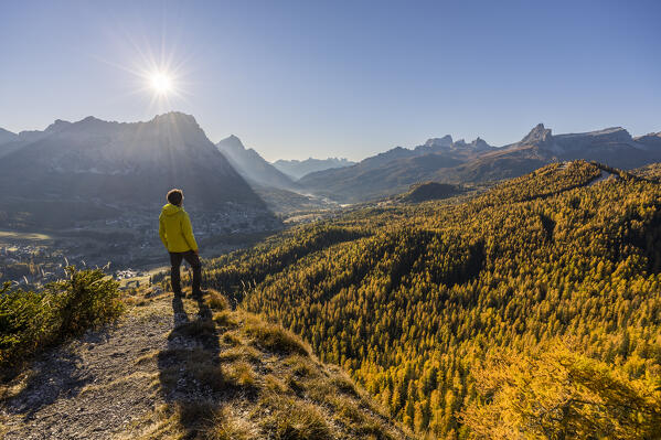 A hiker admires the tourist resort of Cortina d'Ampezzo from a elevated view point, Val Boite, Belluno province, Veneto, Italy (MR)