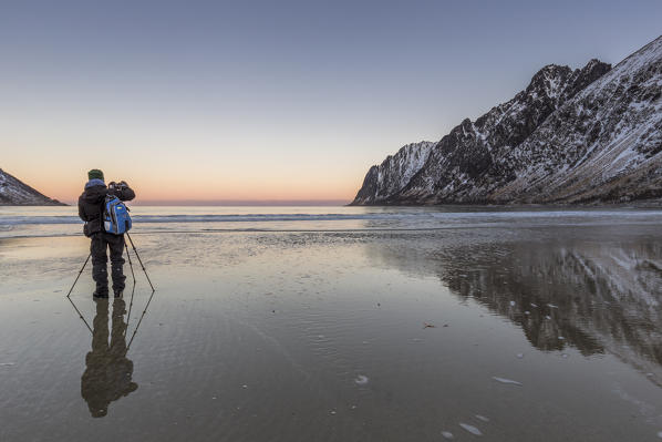 Photographer on the beach of Ersfjord  at dawn,Berg,Senja,Norway,Europe