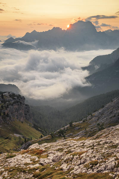 The sun rises in Cortina d'Ampezzo hidden by the morning fog, Belluno district, Veneto, Italy