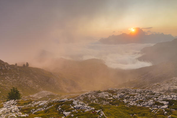 The sun rises in Cortina d'Ampezzo hidden by the morning fog, Belluno district, Veneto, Italy