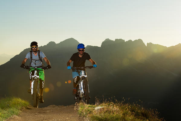 Europe,Dolomites,Italy,Trentino,Fassa valley.
Mountain bikers at sunset