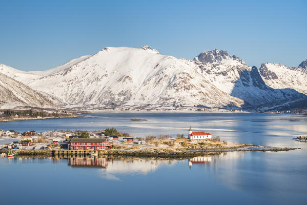 Sildpollneset peninsula with its church and snowcapped mountains in the background. Vestpollen, Nordland county, Northern Norway region, Norway.