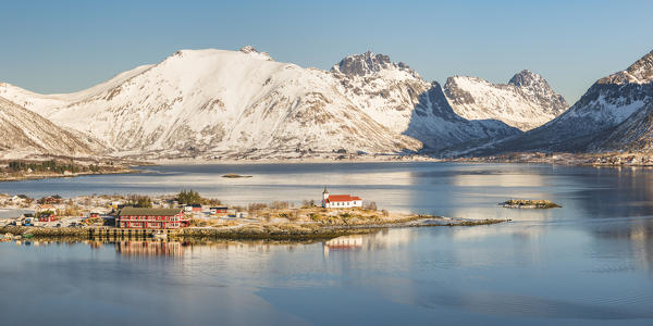 Sildpollneset peninsula with its church and snowcapped mountains in the background. Vestpollen, Nordland county, Northern Norway region, Norway.