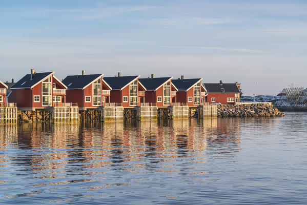 Traditional red houses at sunset in winter. Henningsvaer, Nordland county, Northern Norway region, Norway.
