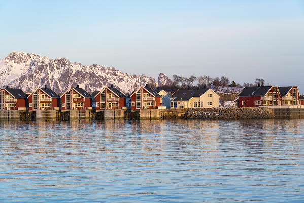 Traditional red houses at sunset in winter. Henningsvaer, Nordland county, Northern Norway region, Norway.