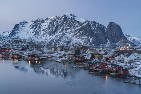 Reine Bay at sunset in winter, with Lilanstinden and Festhelltinden peaks in the background. Reine, Nordland county, Northern Norway, Norway.