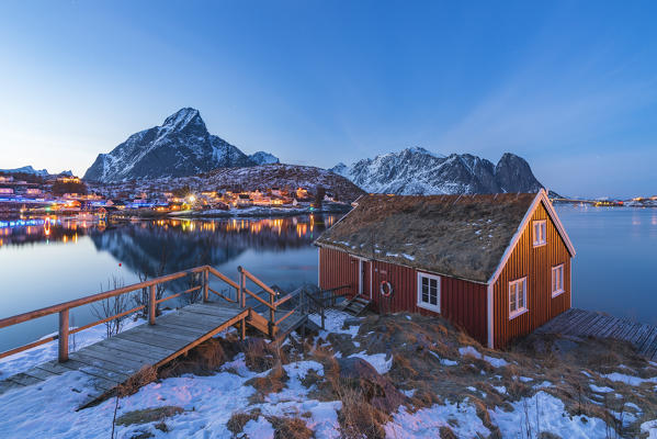 Traditional fishermen house above Reine Bay at dusk in winter. Reine, Nordland county, Northern Norway, Norway.