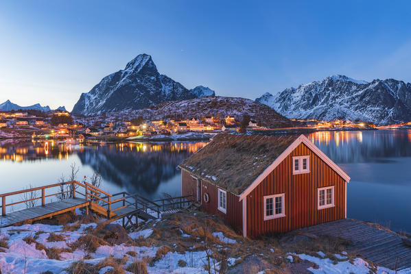 Traditional fishermen house above Reine Bay at dusk in winter. Reine, Nordland county, Northern Norway, Norway.