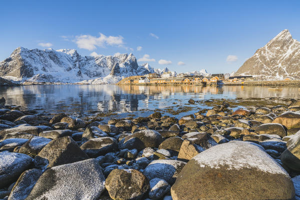 Sariskoy village in winter, with rocky beach in the foreground. Reine, Lofoten district, Nordland county, Northern Norway, Norway.