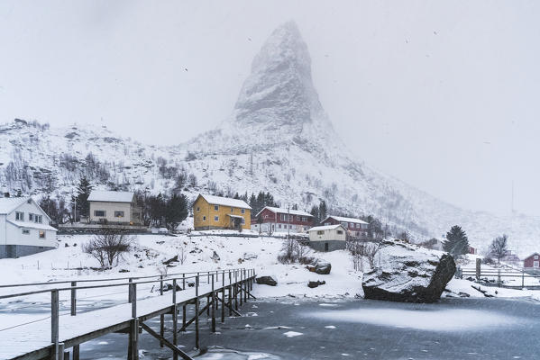 Bridge on the fjord with Hammarskaftet peak in the background covered in mist. Reine, Nordland county, Northern Norway, Norway.