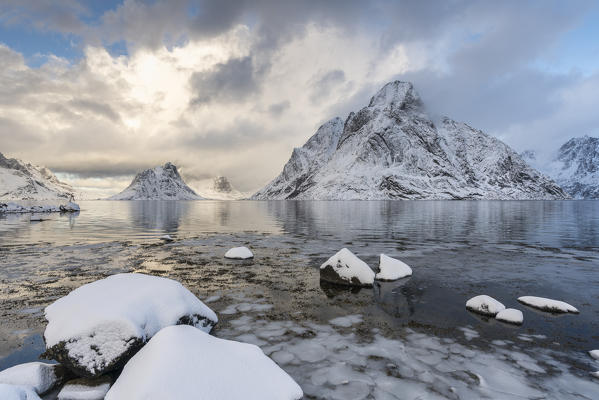 Olstinden peak in winter, with ice and snow on the rocky beach in the foreground. Reine, Nordland county, Northern Norway region, Norway.