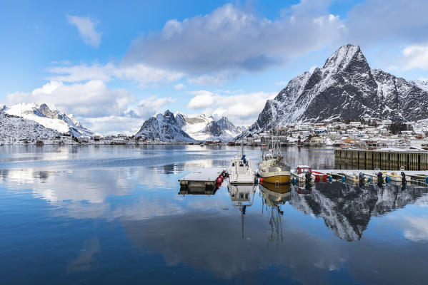 Boats in the harbour, with Olstinden peak in the background in winter. Reine, Lofoten district, Nordland county, Northern Norway, Norway.