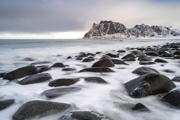 Uttakleiv Beach, with rocks in the fore and mountains in the background. Leknes, Nordland county, Northern Norway, Norway.