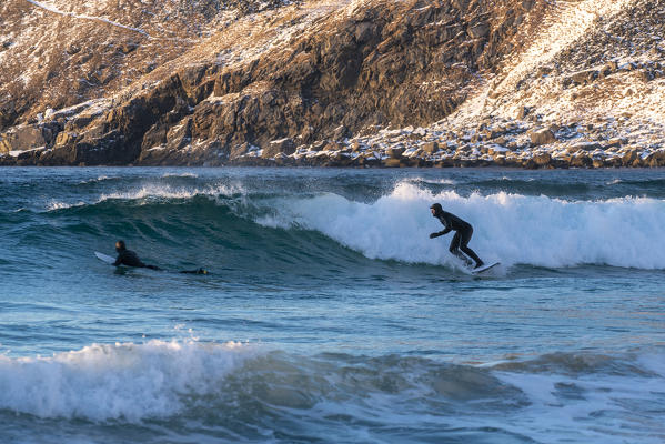 Men surfing at Unstad Beach in winter. Vestvagoy municipality, Nordland county, Northern Norway, Norway.
