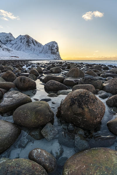 The sun is setting behind Helligberget peak at Unstad Beach. Vestvagoy municipality, Nordland county, Northern Norway, Norway.