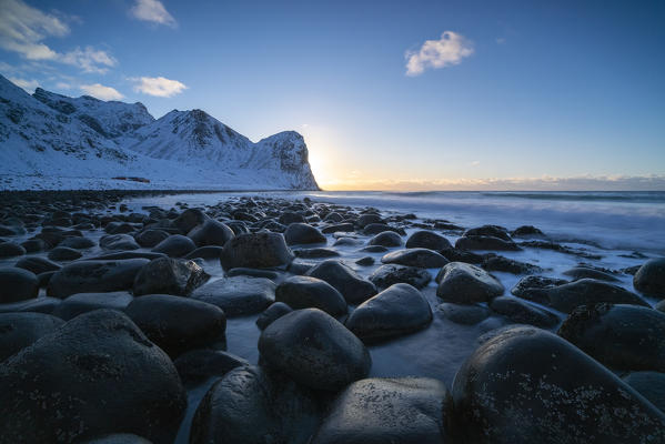 The sun is setting behind Helligberget peak at Unstad Beach. Vestvagoy municipality, Nordland county, Northern Norway, Norway.